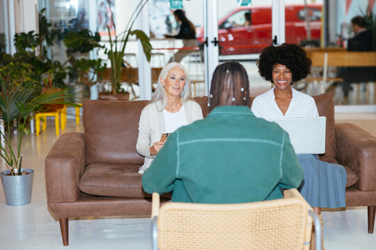 Businesswomen interviewing a young man at modern office