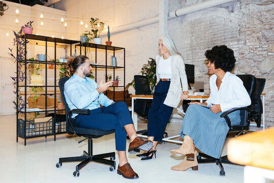 Diverse colleagues looking at each other at office ugc