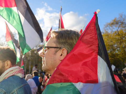 Man carrying Palestinian flag at a protest