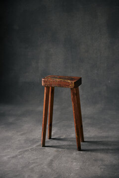 rustic school bench chair in front a blank studio background