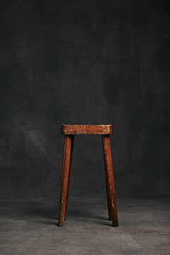 rustic school bench chair in front a blank studio background