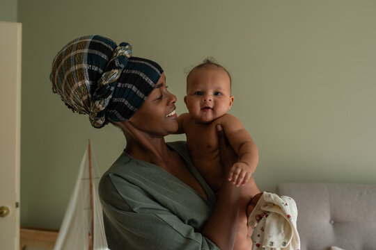 Mother holding smiling baby looking at camera