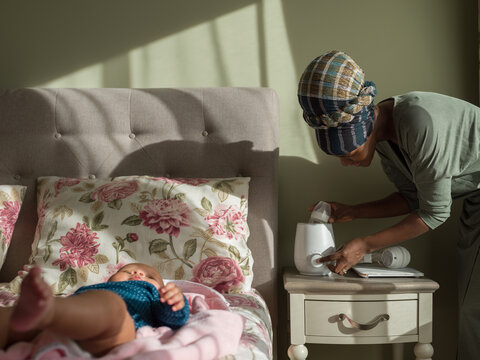 Mother using baby bottle warmer