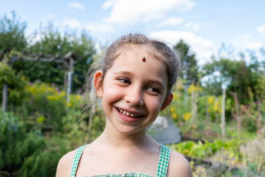 Portrait of a child with a ladybug on her head