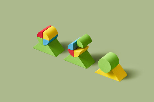 Colorful pieces of wooden cylinder placed on top of triangles