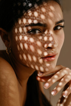 Young woman in makeup with shadow face and spotted light