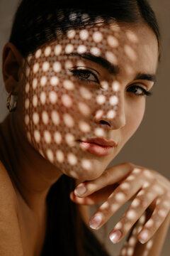 Young calm woman with shadow light effect on face
