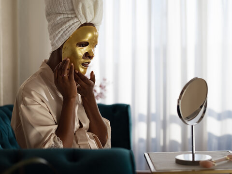 Woman using anti aging skin care mask 