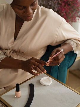 Woman removing cuticles at home