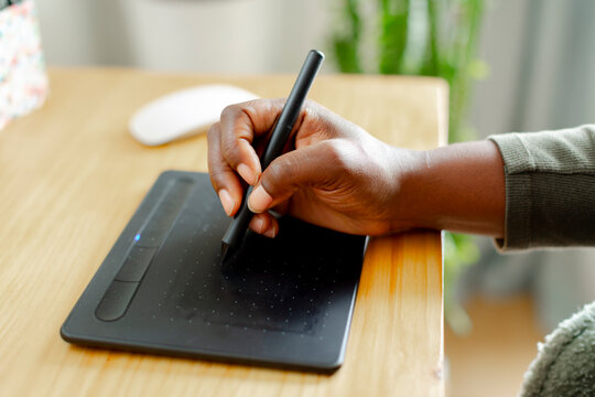 Woman's hand using pen tablet for computer design
