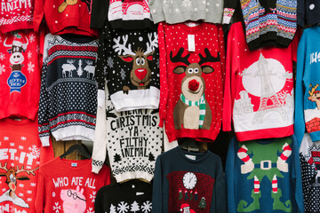 Christmas sweaters hanging from the wall in a Market 