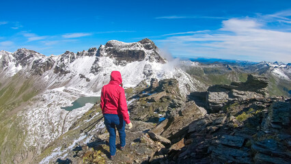 Hiker woman with scenic view of majestic mountain peaks of High Tauern seen from Feldseekopf,...