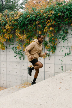 A young man dressed in sportswear exercises outdoors