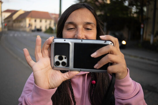 A woman is taking a photo or a video with a phone 