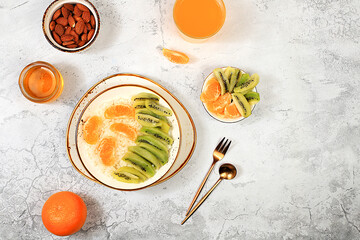 Healthy breakfast with ingredients, Rice pudding with kiwi, honey, tangerines and almonds.flat lay, Healthy and natural food concept, lifestyle, food for children,