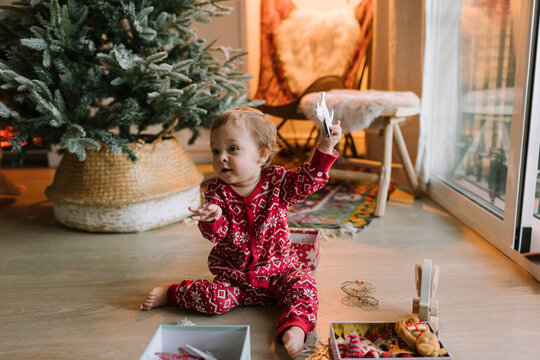 Baby girl enjoying with Christmas tree decorations