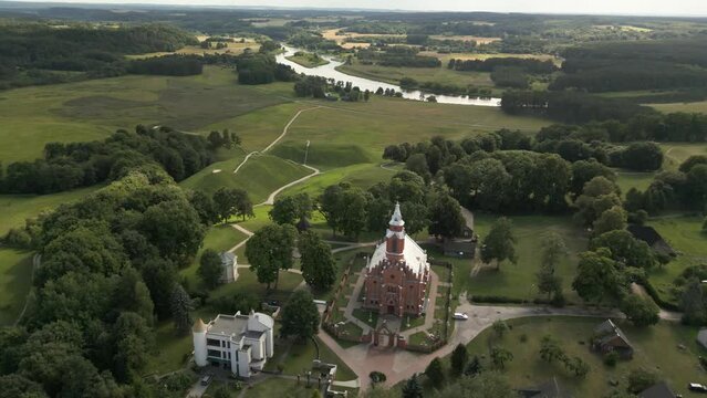 A drone is flying over the historical mounds in Kernave with the church in the distance