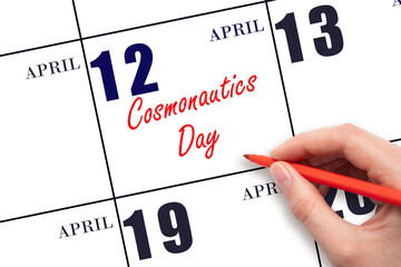 April 12. Hand writing text Cosmonautics Day on calendar date. Save the date.