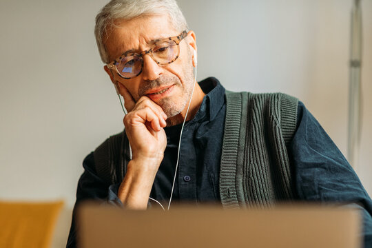 Elderly man watching video on his laptop