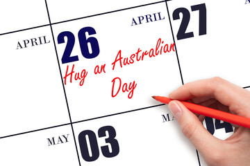April 26. Hand writing text Hug an Australian Day on calendar date. Save the date. © Alena