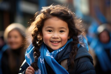 A young girl wearing a blue scarf around her neck