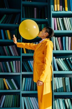 Woman blowing balloon and trying to touch new dimension