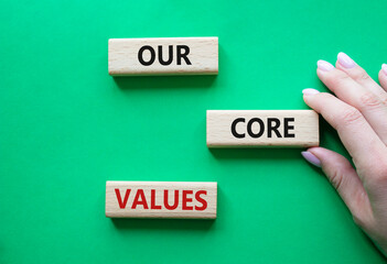 Our core values symbol. Concept words Our core values on wooden blocks. Beautiful green background....