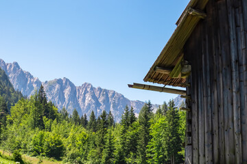 Wooden hut with scenic view of majestic mountain ridges of Karawanks in Bodental, Carinthia,...