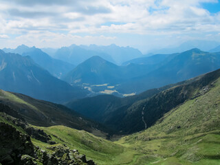 Obraz premium Panoramic view of alpine terrain surrounded by majestic Carnic Alps, Carinthia, border Italy Austria. Scenic hiking trail in wilderness of Austrian Alps. Peace of mind, calmness. Wanderlust in nature