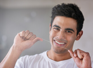 Happy, portrait and man with floss in bathroom for dental hygiene, gum disease and oral care....