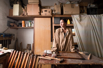 Happy female carpenter at small workshop