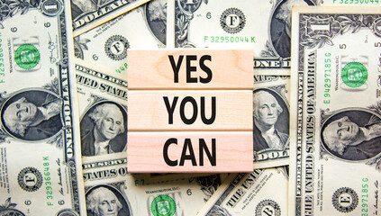 Motivational and Yes you can symbol. Concept words Yes you can on beautiful wooden blocks. Dollar bills. Beautiful dollar bills background. Business motivational and Yes you can concept. Copy space.