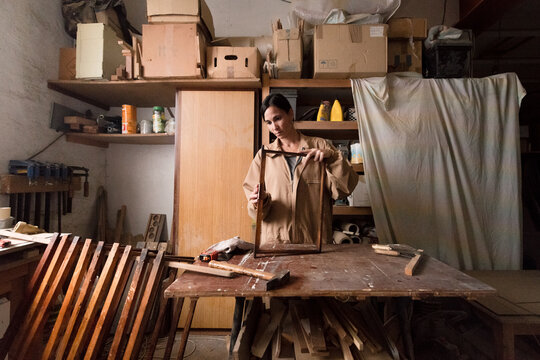 Female carpenter working at small studio