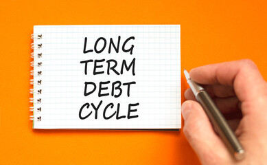 Long term debt cycle symbol. Concept words Long term debt cycle on beautiful white note. Beautiful orange background. Businessman hand. Business Long term debt cycle concept. Copy space.
