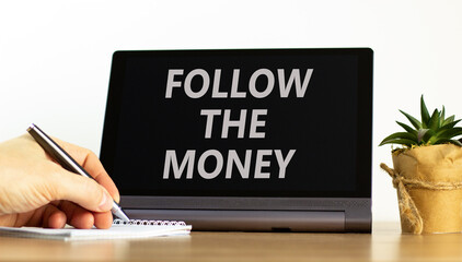 Follow the money symbol. Concept words Follow the money on beautiful tablet screen. Beautiful...
