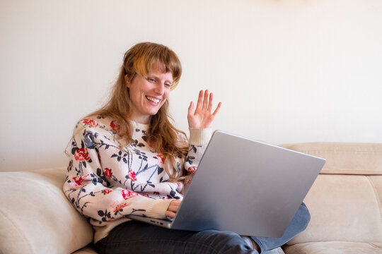 Woman waving on a video call meeting