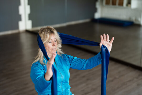 A woman doing neck stretching in a gym