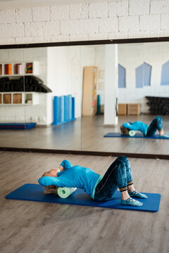 Mature woman doing postural exercises in the gym