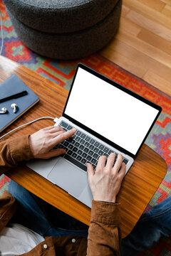 Man typing on a laptop with white screen