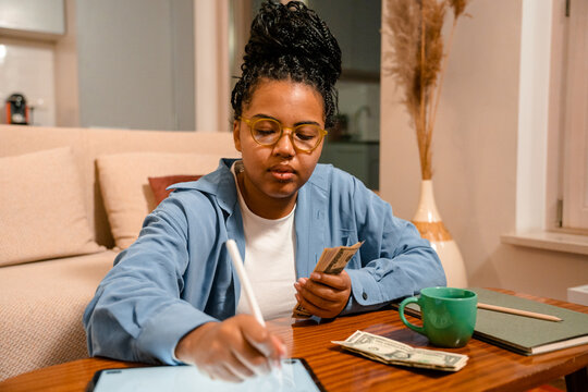 A woman counts money at home