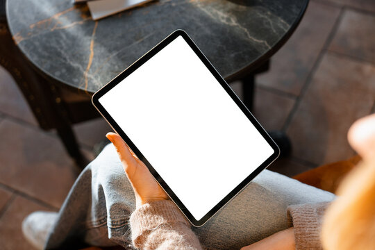 A tablet with white screen in women's hands