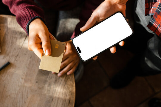 The woman puts the card to the phone for payment