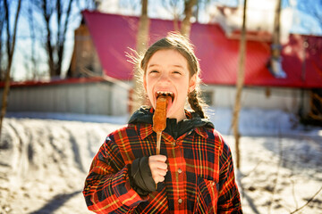 Photo showing children tasting maple syrup with wooden spoon - 777683272