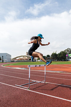 A professional athlete practices her hurdle jumps
