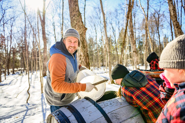 sugar shack, a maple farmer wearing a traditional clothe working take maple water - 777683644