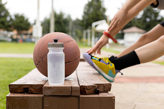 Close-up of an amphora and a basketball on a wooden bench in a park