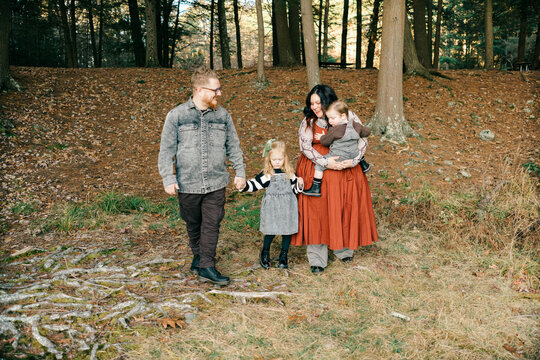 family of four in the fall, holding hands