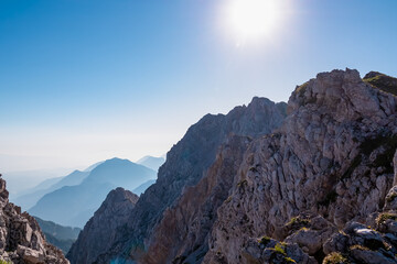 Scenic view of majestic mountain summit cross of Vertatscha (Vrtaca) in untamed Karawanks, border Slovenia Austria. Hiking trail along steep rock cliffs and wilderness of Slovenian Alps in summer