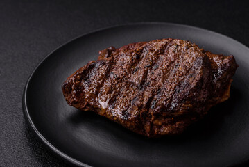 Fresh juicy delicious beef steak on a dark background