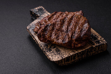 Fresh juicy delicious beef steak on a dark background
